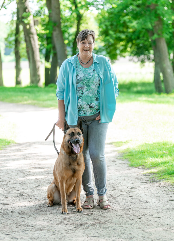Eine Frau spaziert mit ihrem Haustier im Park.